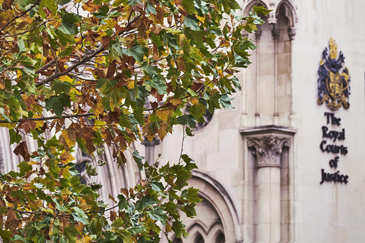 Golden leaves and the signage of the Royal Courts of Justice photographed in Autumn.